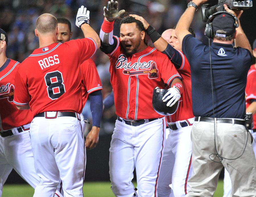 The Atlanta Braves Juan Francisco, middle, is surrounded by teammates to celebrate his game-winning RBI single against the Los Angeles Dodgers in the 11th inning at Turner Field in Atlanta, Georgia, on Friday, August 17, 2012. (Hyosub Shin/Atlanta Journal-Constitution/MCT)