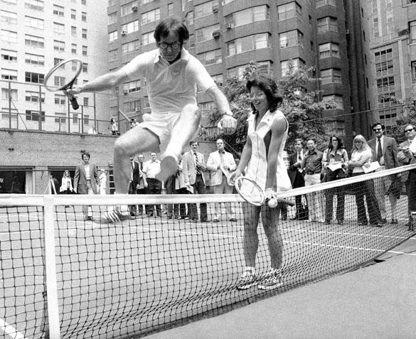 Wimbledon Champ Billie Jean King holds down the net as Bobby Riggs, the 55-year-old tennis player she played in the game that was billed as the battle of the sexes, jumps over the net. (MCT)